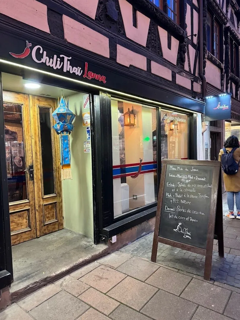 La devanture : maison à colombages rose et noire, enseigne Chili Thaï Lanna, lanterne bleue et ardoise du menu du jour